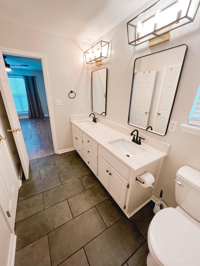 bathroom with double vanity, tile patterned floors, toilet, and a sink