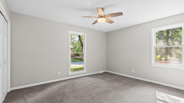 spare room with ceiling fan and carpet