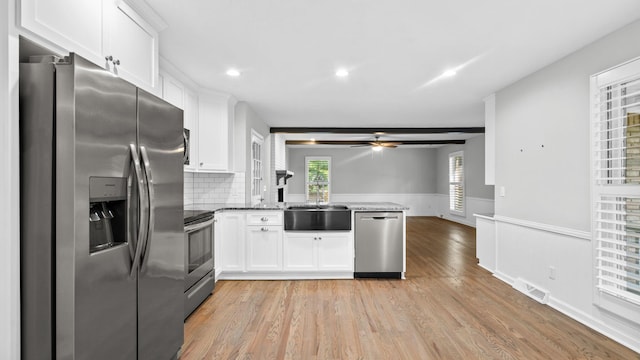 kitchen featuring white cabinets, ceiling fan, backsplash, and appliances with stainless steel finishes