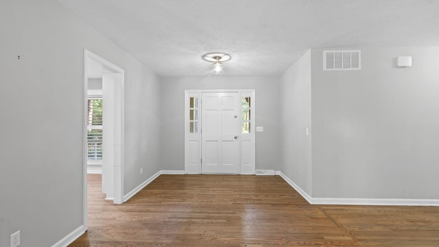 entrance foyer featuring wood-type flooring and a textured ceiling