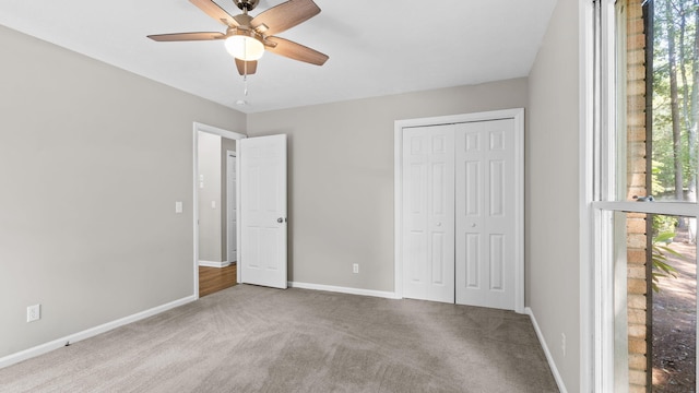 unfurnished bedroom featuring a closet, light colored carpet, and ceiling fan