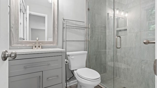 bathroom with vanity, toilet, and a shower with door