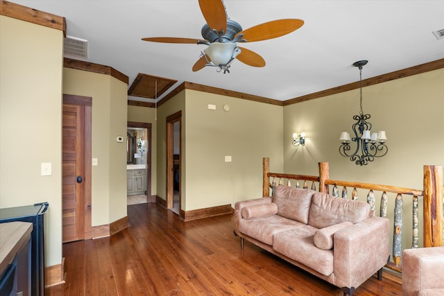 living room with ceiling fan with notable chandelier, dark hardwood / wood-style floors, and ornamental molding