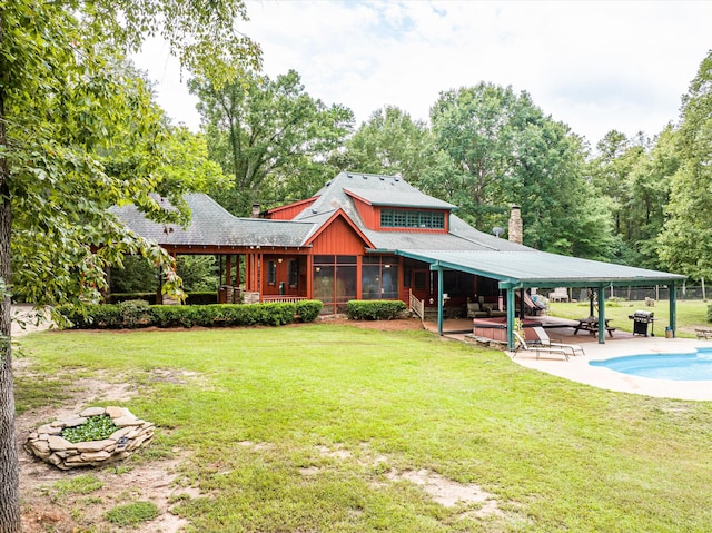 back of property with a sunroom, a yard, and a patio