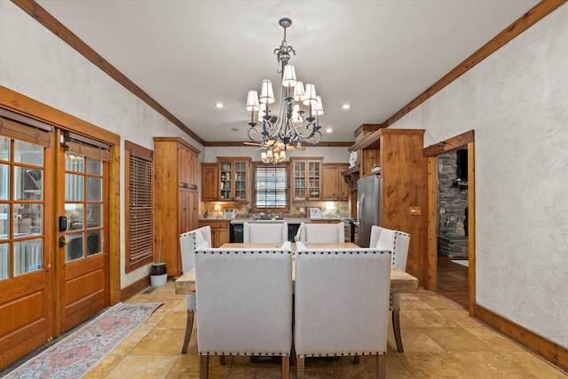 dining room with french doors, crown molding, and an inviting chandelier