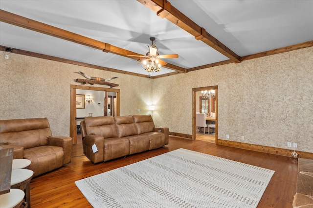 living room featuring beam ceiling, wood-type flooring, and ceiling fan with notable chandelier