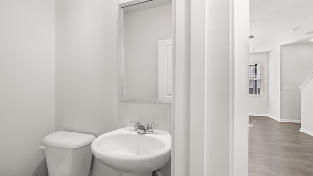 bathroom featuring sink, wood-type flooring, and toilet