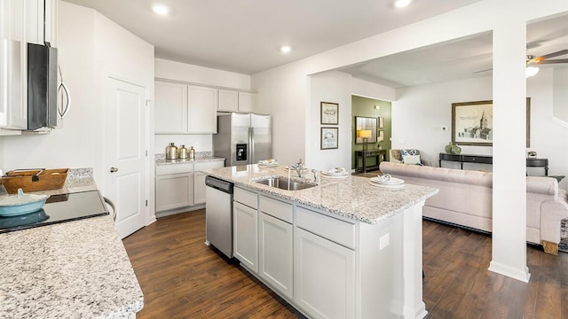 kitchen with sink, appliances with stainless steel finishes, dark hardwood / wood-style flooring, a kitchen island with sink, and white cabinets