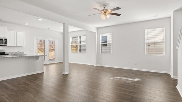 unfurnished living room with ceiling fan and dark hardwood / wood-style flooring