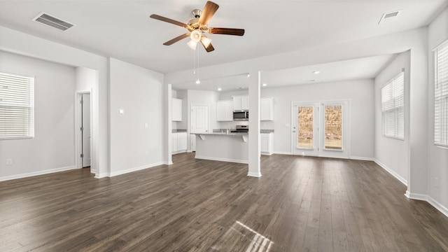 unfurnished living room featuring dark hardwood / wood-style floors and ceiling fan