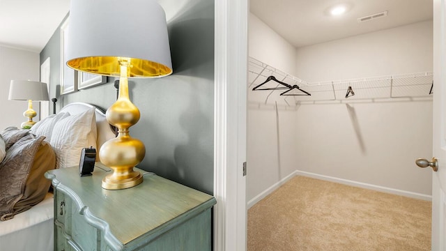 walk in closet with light colored carpet