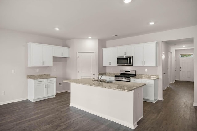 kitchen featuring a kitchen island with sink, stainless steel appliances, and white cabinets