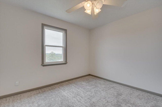 carpeted spare room featuring ceiling fan