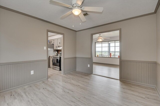 spare room featuring ceiling fan, light hardwood / wood-style floors, and ornamental molding