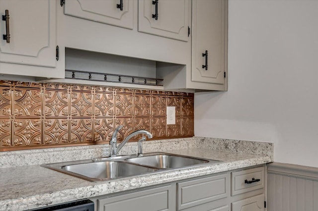 kitchen with dishwasher, white cabinetry, and sink