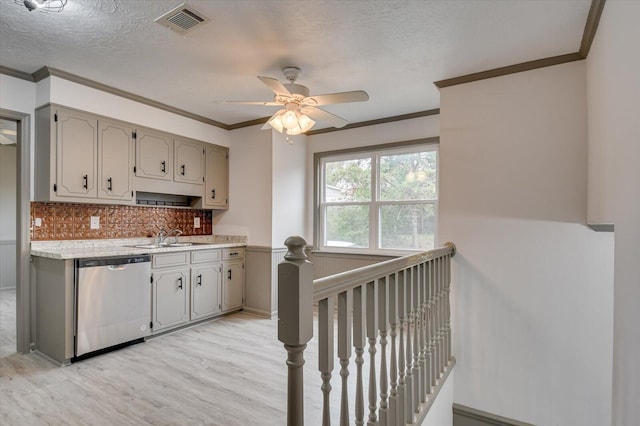 kitchen featuring dishwasher, backsplash, sink, crown molding, and light wood-type flooring