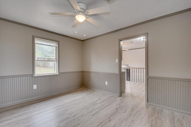 unfurnished room featuring ceiling fan, crown molding, and light hardwood / wood-style flooring