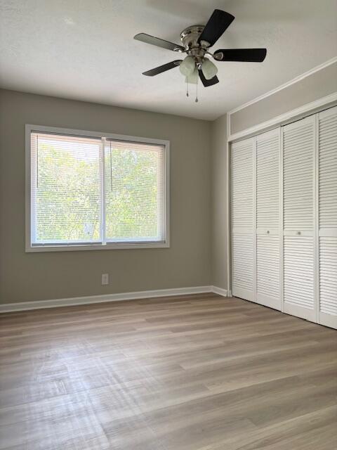 2060 Morning Dr, Augusta, GA 30906 - unfurnished bedroom featuring multiple windows, a closet, and wood finished floors