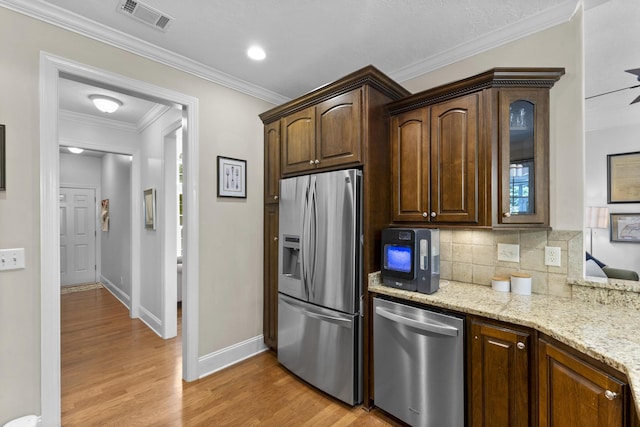 108 Pine Needle Rd, Aiken, SC 29803 - kitchen featuring stainless steel appliances, light wood finished floors, decorative backsplash, light stone countertops, and ornamental molding
