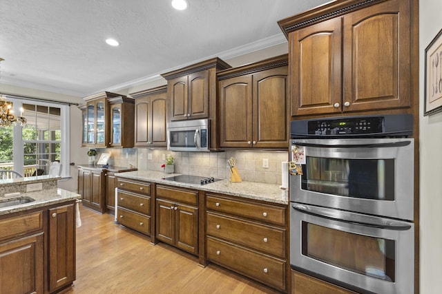 108 Pine Needle Rd, Aiken, SC 29803 - kitchen featuring appliances with stainless steel finishes, ornamental molding, tasteful backsplash, light wood-type flooring, and a sink