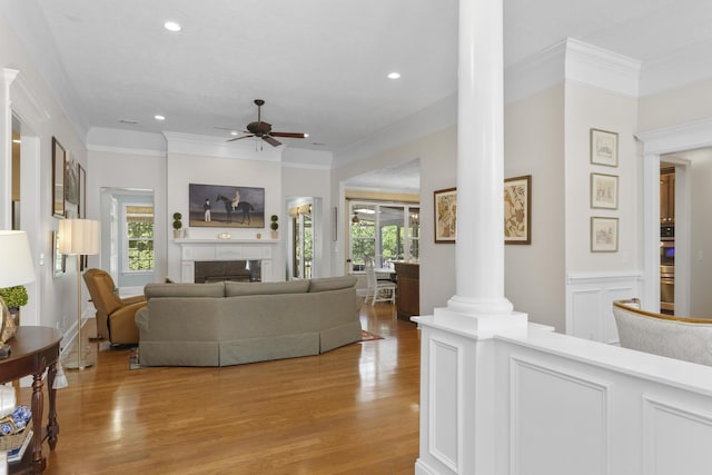 108 Pine Needle Rd, Aiken, SC 29803 - living room featuring ornate columns, light wood finished floors, ceiling fan, a fireplace, and ornamental molding
