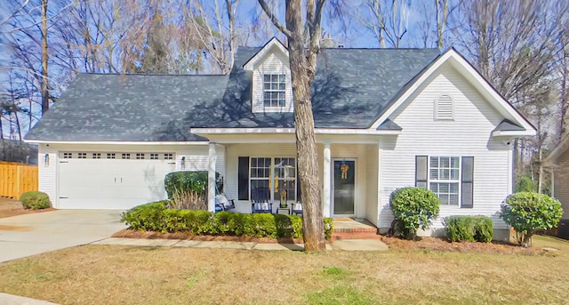 view of front of property with a porch, an attached garage, fence, driveway, and a front lawn