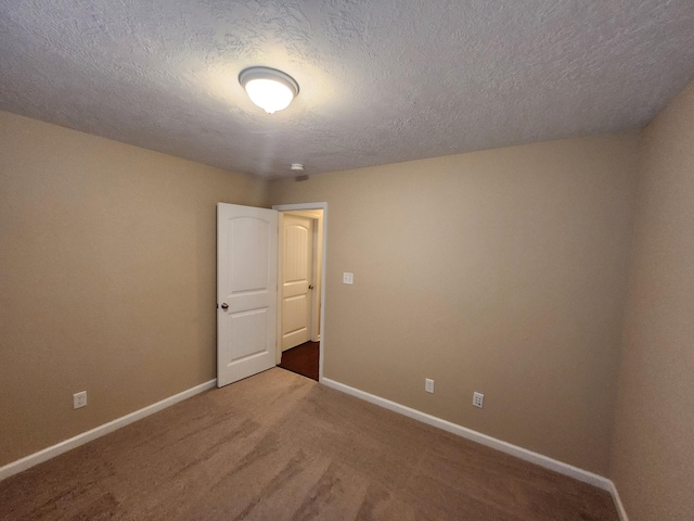 carpeted empty room with a textured ceiling