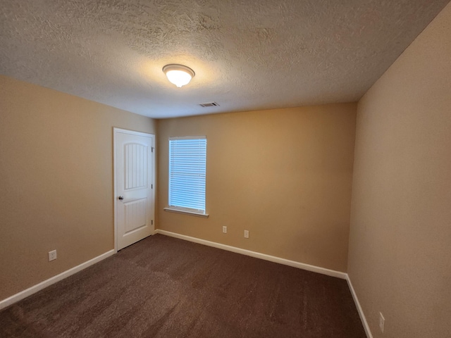 carpeted empty room with a textured ceiling