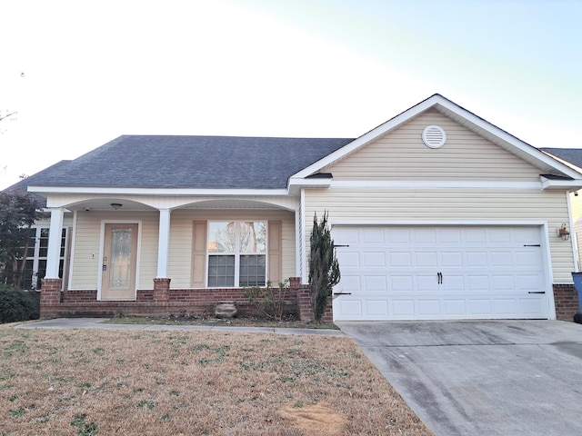 single story home with a front lawn, covered porch, and a garage