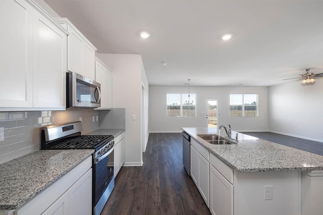 kitchen featuring stainless steel appliances, white cabinetry, a center island with sink, and sink