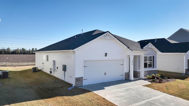 exterior space featuring a garage, central air condition unit, and a yard