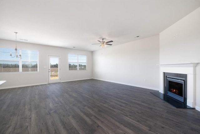 unfurnished living room featuring dark hardwood / wood-style floors and ceiling fan with notable chandelier