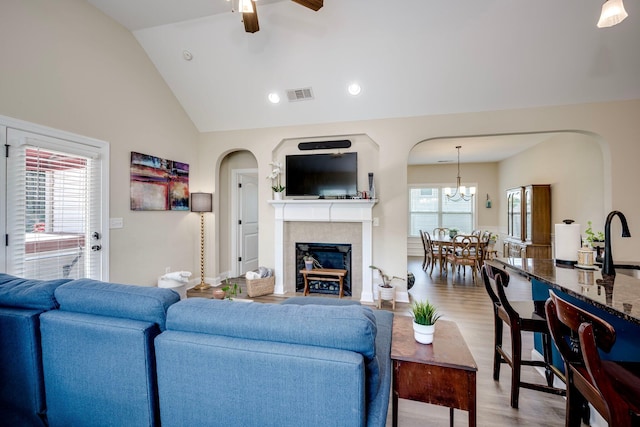 2306 Peach Blossom Pass, Hephzibah, GA 30815 - living room with ceiling fan, wood finished floors, a tile fireplace, lofted ceiling, and arched walkways