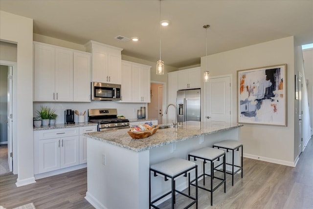 kitchen with sink, white cabinetry, an island with sink, and appliances with stainless steel finishes