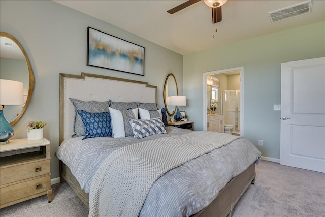 carpeted bedroom with ensuite bath and ceiling fan