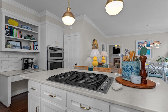 kitchen featuring light countertops, stainless steel appliances, open shelves, and ornamental molding