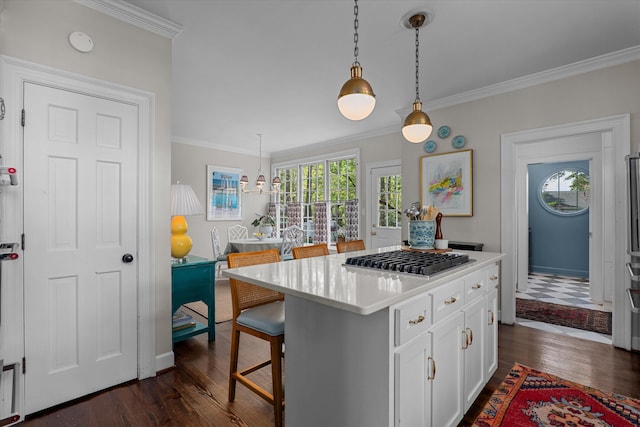 kitchen with dark wood-type flooring, crown molding, white cabinetry, and stainless steel gas cooktop