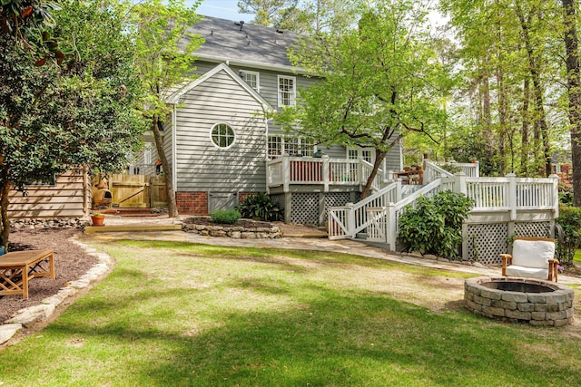 view of yard with a fire pit, a deck, and stairway