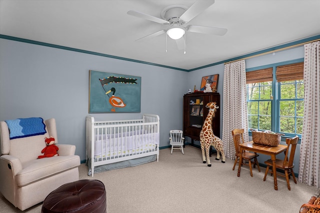 bedroom with carpet floors, a ceiling fan, and a nursery area
