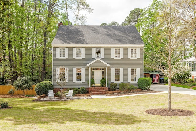colonial house featuring a chimney, a front lawn, fence, and crawl space