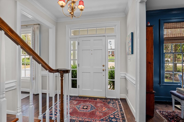 entryway with an inviting chandelier, crown molding, stairs, wood finished floors, and baseboards