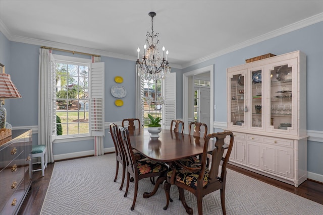 dining room featuring a healthy amount of sunlight, crown molding, dark wood-type flooring, and a notable chandelier