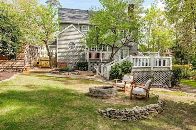 view of yard featuring a deck, a gate, and an outdoor fire pit