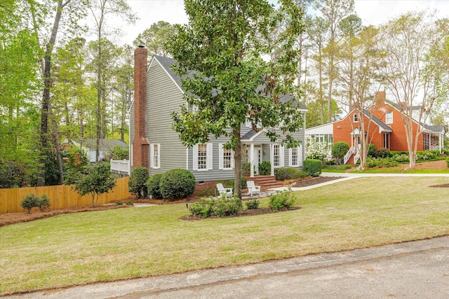 obstructed view of property featuring fence, a chimney, and a front lawn
