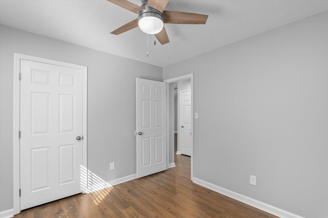 unfurnished bedroom with dark wood-type flooring and ceiling fan