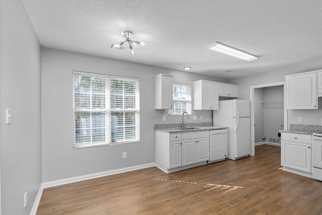 kitchen featuring white appliances, white cabinetry, sink, and dark hardwood / wood-style flooring