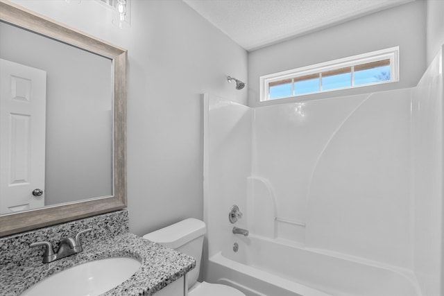 full bathroom with toilet, vanity, a textured ceiling, and washtub / shower combination