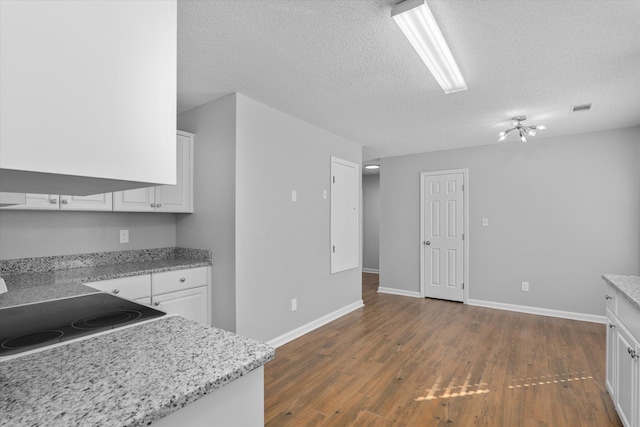 kitchen featuring white cabinetry, dark hardwood / wood-style floors, light stone countertops, and a textured ceiling