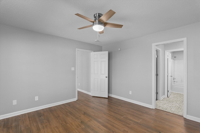 unfurnished room with ceiling fan, dark hardwood / wood-style flooring, and a textured ceiling