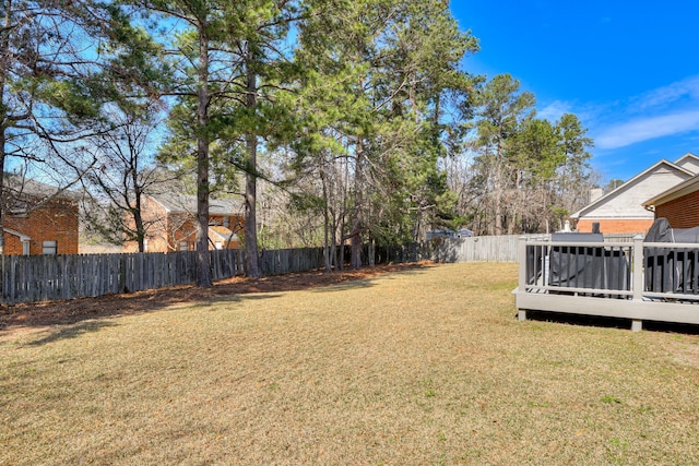 view of yard with a fenced backyard, a sunroom, and a wooden deck